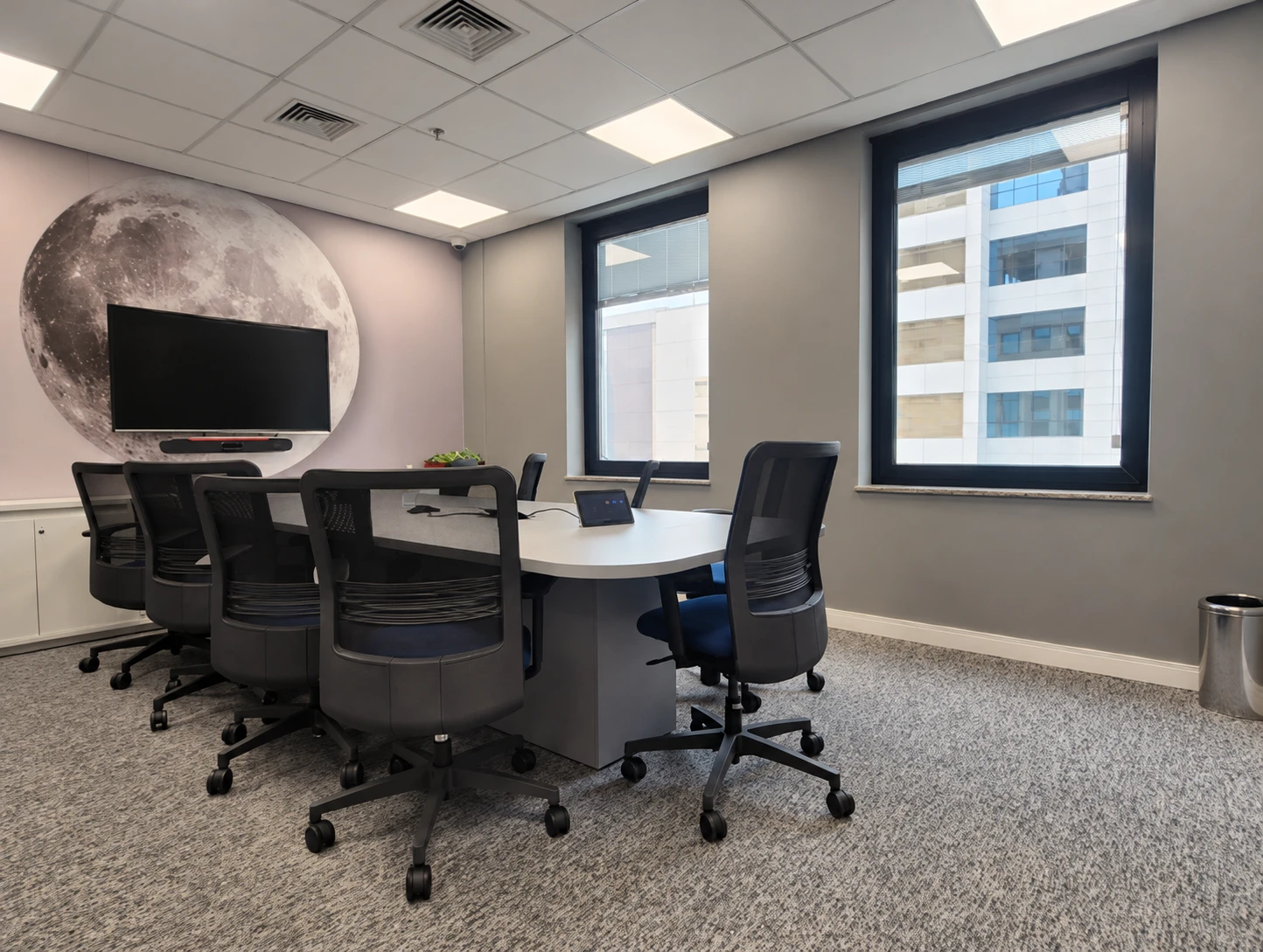Sala de reuniões com cadeiras, carpete e mural lunar